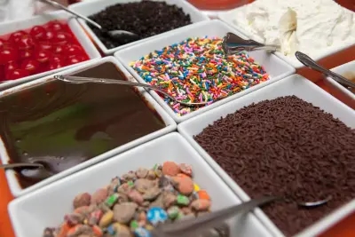 A tray of exciting ice cream toppings, including chocolate sauce, sprinkles and candy!