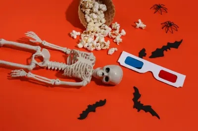 A skeleton with bats, popcorn and 3D movie glasses, ready for a scary Halloween move!