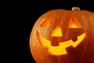 A brightly lit pumpkin with a spooky face carved out!