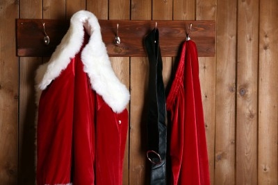 Santa's red jacket, trousers and his belt hanging on coat hooks.