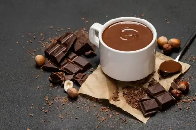 A mug of sweet hot chocolate, alongside rich blocks of chocolate.