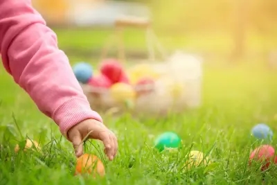 A little girl grabbing an Easter egg