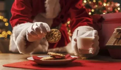 Santa Claus picking out a delicious cookie to dunk in his glass of milk during a Christmas Eve delivery!